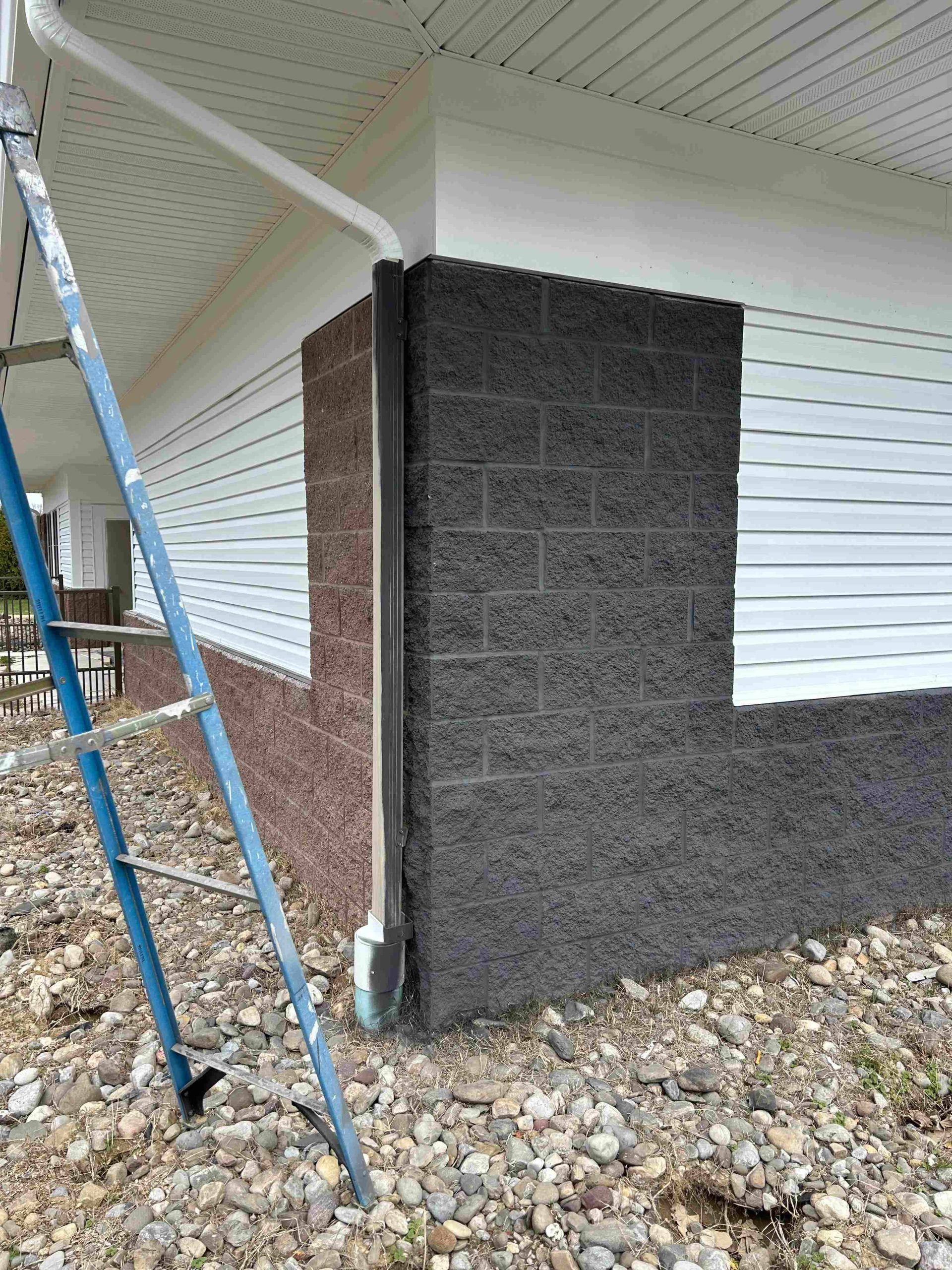 Commercial building with white siding and black stained block