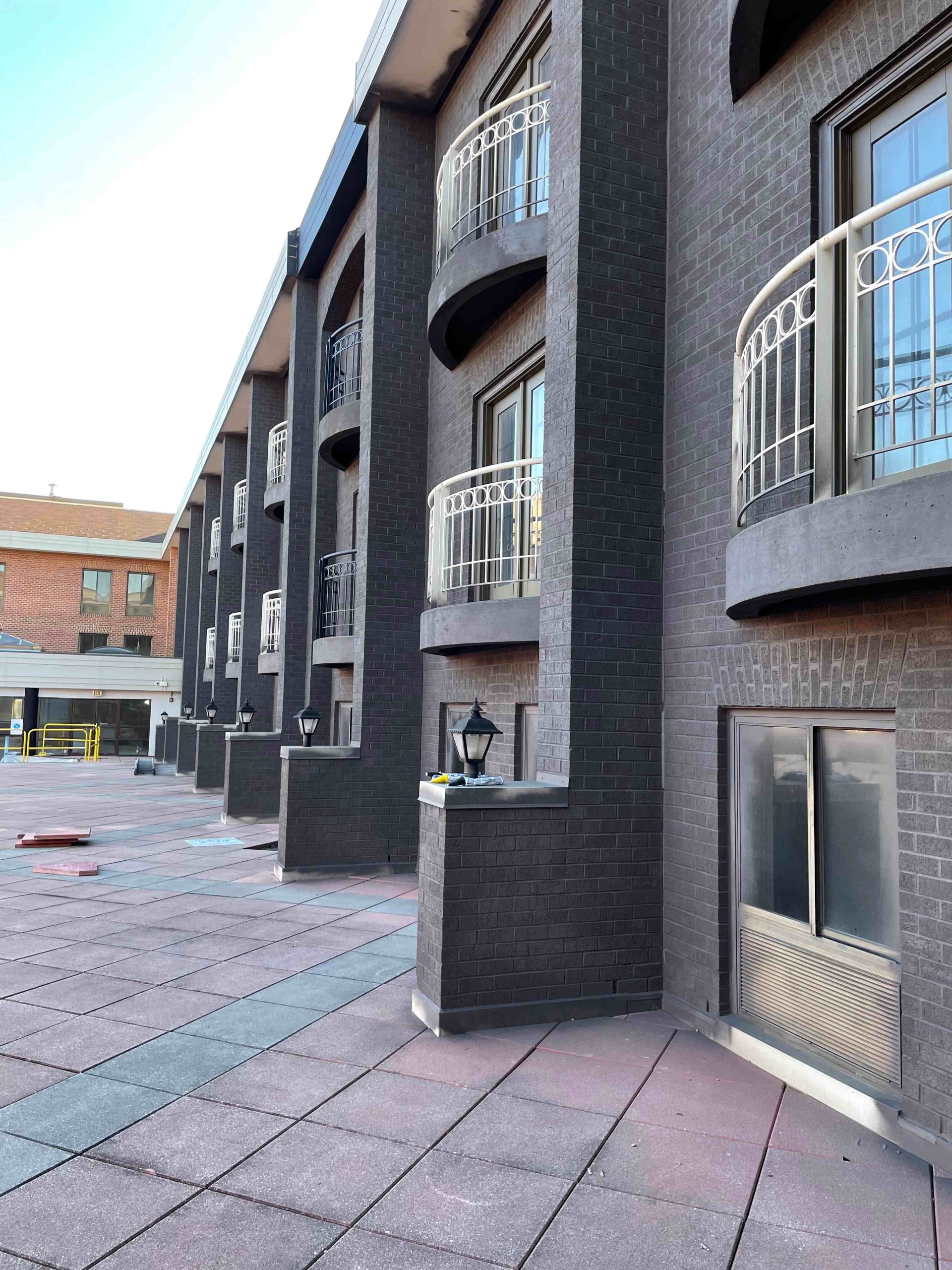Dark brick apartment building with lanterns after staining